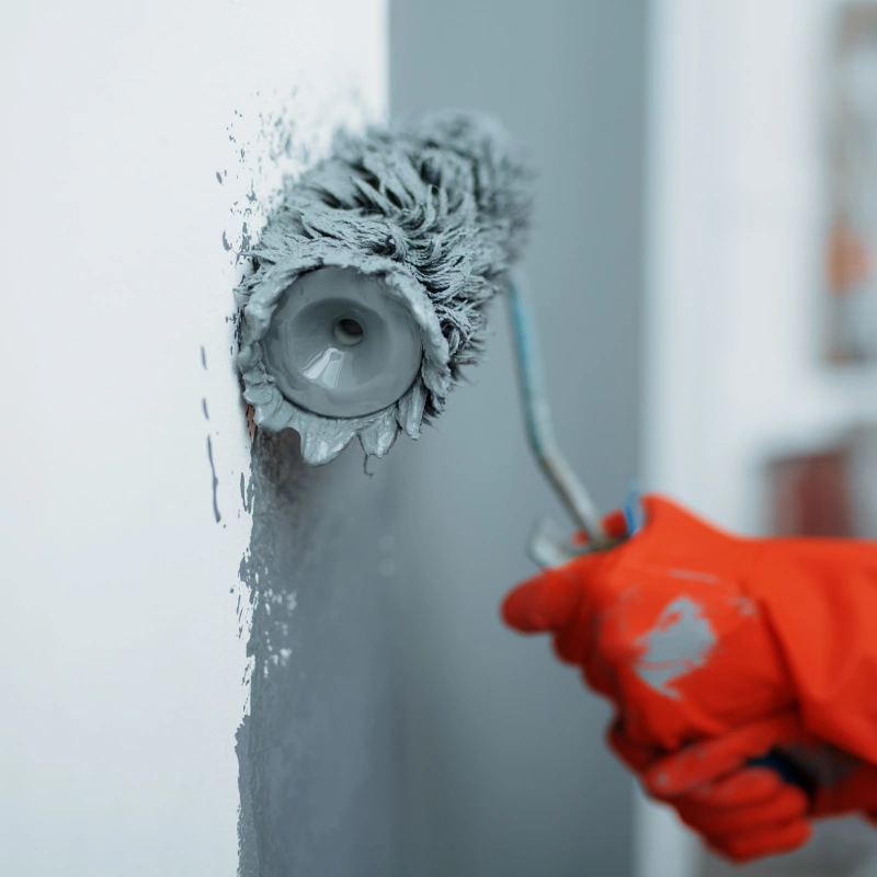 orange gloves with gray rollers and paint